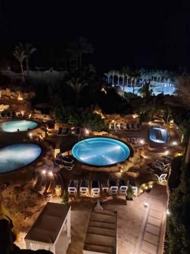 widok na dwa baseny w nocy w obiekcie Domina Coral Bey Harem w Szarm el-Szejk