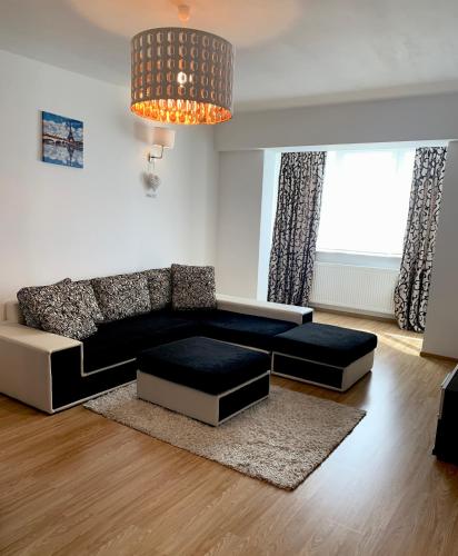 a living room with a black and white couch at Sunny Central Apartments Suceava in Suceava