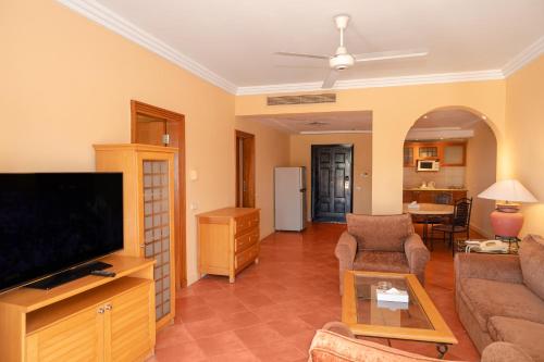 a living room with a tv and a couch at Sharm Dreams Vacation Club - Aqua Park in Sharm El Sheikh