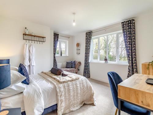 1 dormitorio con cama y escritorio en Longridge en Peldon