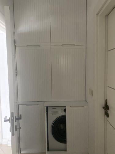 una lavatrice e asciugatrice in una stanza con porta di Konforlu,keyifli. a Emin Sitesi