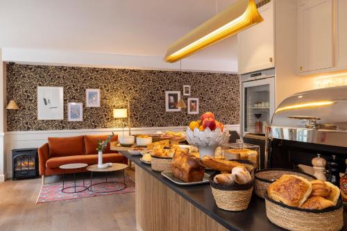 - une cuisine avec un comptoir avec du pain et des viennoiseries dans l'établissement Le Petit Oberkampf Hotel & Spa, à Paris