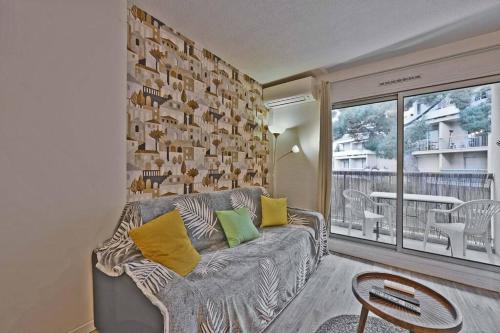 un salon avec un canapé et une table dans l'établissement Les Comtadins - PARKING Gratuit - Balcon - Clim, à Avignon