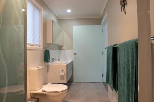 a bathroom with a toilet and a sink and a shower at 2 Bedroom Studio - Korindi BnB - Batemans Bay Area in Long Beach