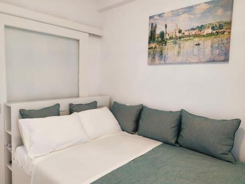 a white couch in a room with a painting on the wall at Sunset by the sea 2 in Loutraki
