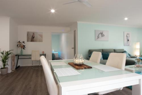 Long Beach的住宿－2 Bedroom Studio - Korindi BnB - Batemans Bay Area，用餐室以及带桌椅的起居室。