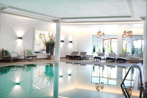 uma sala de estar com piscina e uma casa em Hotel Bayerischer Hof em Oberstaufen