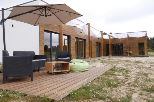 a house with a wooden deck with an umbrella at Quinta da Carreirinha in Vila Franca das Naves