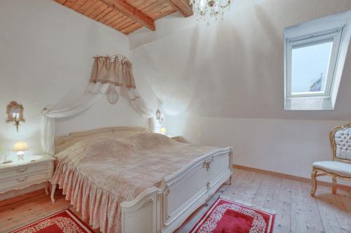 a bedroom with a bed and a chair and a window at Nordpalais vor Sylt in Emmelsbüll-Horsbüll