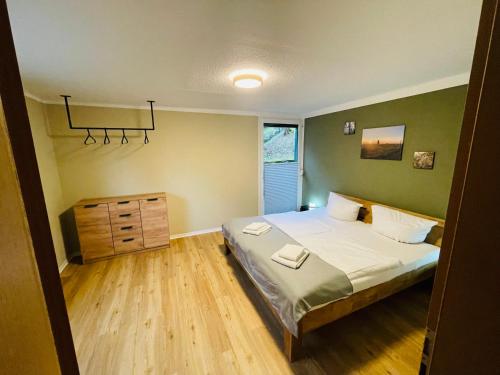 Schlafzimmer mit einem Bett und Holzboden in der Unterkunft Kleine Wohnung am Bach in Neuwerk