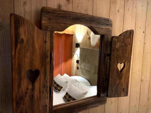 lustro z drewnianą ramą na ścianie w obiekcie Hôtel Le Labrador 1971 w mieście Les Gets