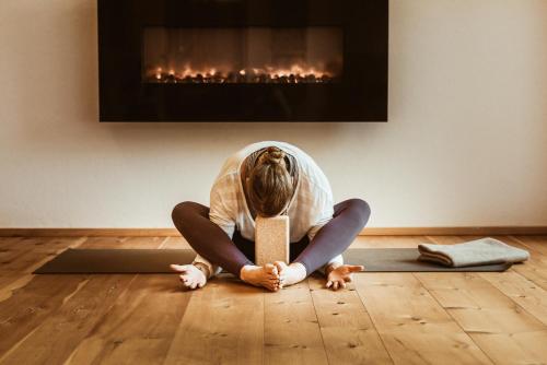 a woman sitting on the floor in front of a fireplace at Natur- & Genießerhotel Der Birkenhof in Oberstaufen
