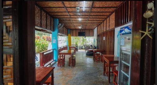 a dining room with tables and chairs in a building at Tres Islas Hostel in General Luna