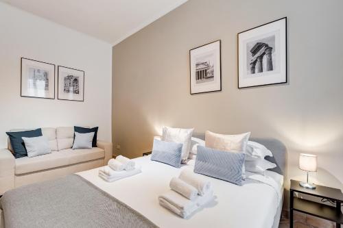 a bedroom with a white bed and a couch at Pantheon Boutique Apartment "La Dolce Vita" in Rome