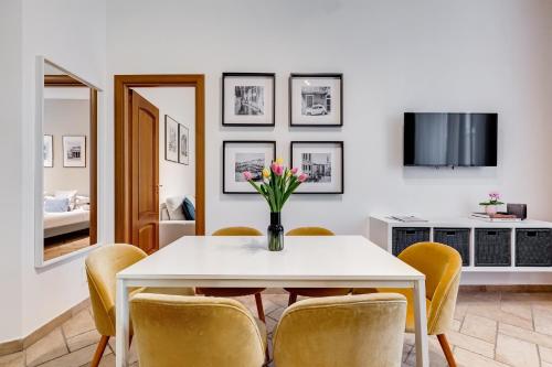 a dining room with a white table and yellow chairs at Pantheon Boutique Apartment "La Dolce Vita" in Rome