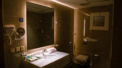 a bathroom with a sink and a mirror at فندق سنبات بلاتينيوم in Jazan