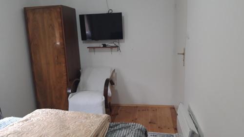 ein Schlafzimmer mit einem Bett und einem TV an der Wand in der Unterkunft GUESTHOUSE TARA in Kolašin