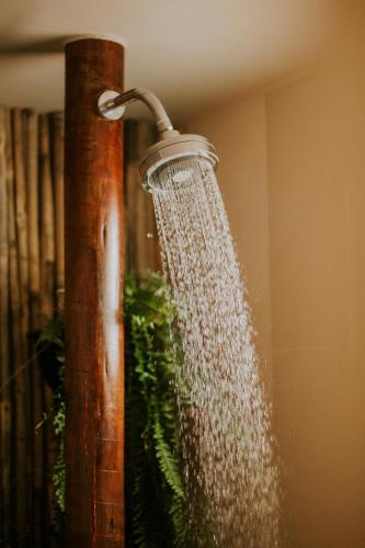 a shower with a water hose attached to a pole at Vila Toá in Alto Paraíso de Goiás