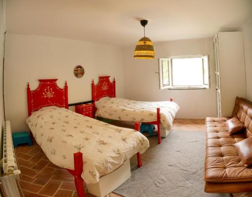 1 dormitorio con 2 camas y sofá en Eco Casinha do Barrocal, 