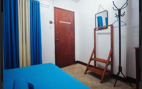 a room with a table and a chair and a door at Tres Islas Hostel in General Luna