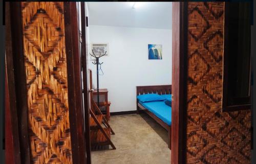 a door leading to a bedroom with a bed at Tres Islas Hostel in General Luna