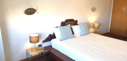 sypialnia z dużym łóżkiem z 2 lampami w obiekcie Charming apartment & parking by ANTHEA HOMES w Grado