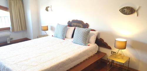 a bedroom with a large bed with blue pillows at Charming apartment & parking by ANTHEA HOMES in Grado