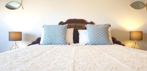 a bedroom with a bed with blue and white pillows at Charming apartment & parking by ANTHEA HOMES in Grado
