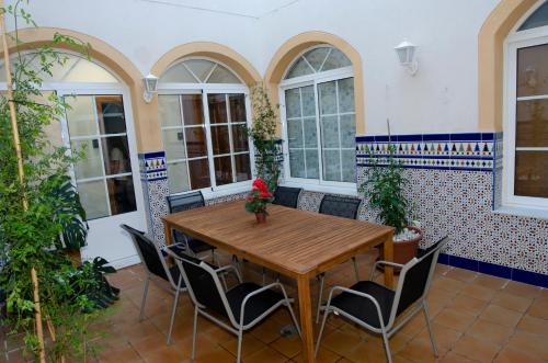 a dining room with a wooden table and chairs at Casa del Patio Andaluz in Málaga