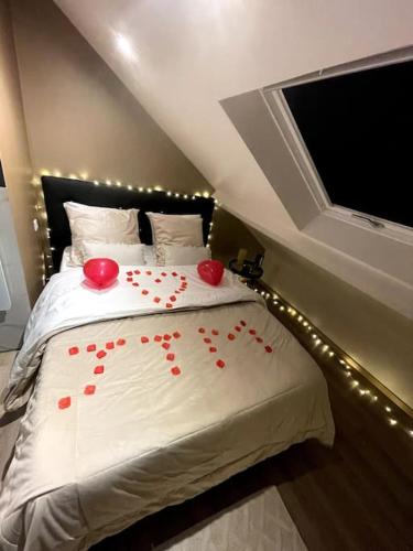 Un dormitorio con una cama con corazones rojos. en Initimy Spa, en Sainte-Savine
