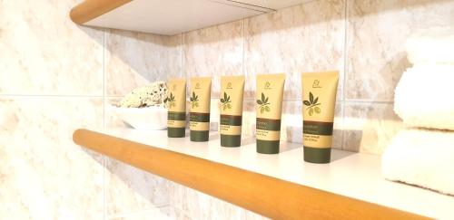 a shelf with four products on it in a bathroom at Charming apartment & parking by ANTHEA HOMES in Grado