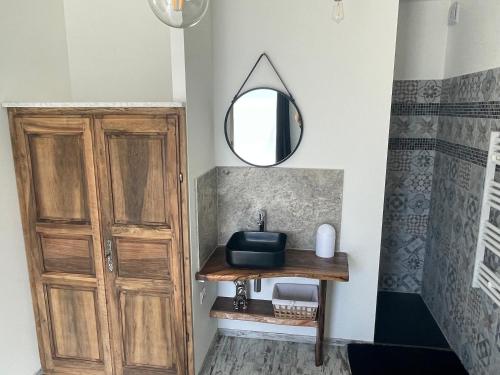 a bathroom with a wooden sink and a mirror at ( Mine de rien ) in Grambois