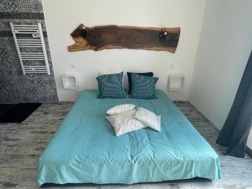 a bedroom with a bed with blue sheets and pillows at ( Mine de rien ) in Grambois