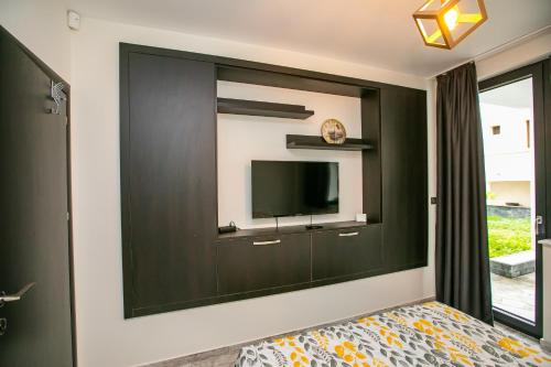 a bedroom with a wall with a flat screen tv at Apartment Dafni in Sandanski