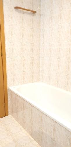 a white bath tub in a bathroom with a shower at Charming apartment & parking by ANTHEA HOMES in Grado