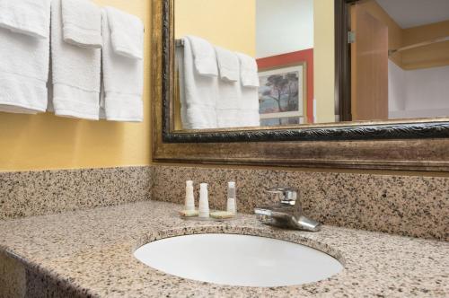 a bathroom counter with a sink and a mirror at Baymont by Wyndham Springfield IL in Springfield