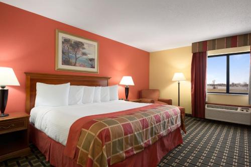 um quarto de hotel com uma cama grande e uma janela em Baymont by Wyndham Springfield IL em Springfield