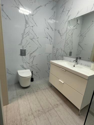 a bathroom with a white sink and a toilet at Sky apartments Budova in Odesa