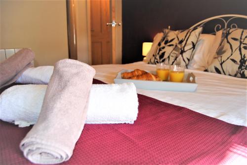 a bed with two towels and a tray of food at Snowdon Cottage 2 in Llanrug