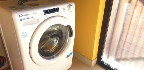 a washing machine is sitting next to a window at Charming apartment & parking by ANTHEA HOMES in Grado