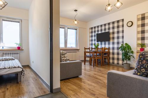 a living room with a couch and a dining room at ENERGYLANDIA Zator Apartament Asia in Zator