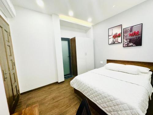 ホーチミン・シティにあるThái Vân Homeの白いベッドルーム(ベッド1台、鏡付)