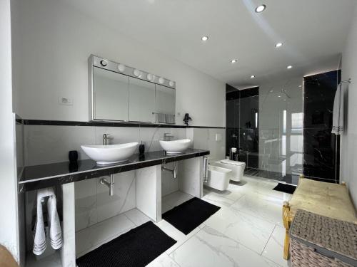 ein weißes Bad mit 2 Waschbecken und einer Dusche in der Unterkunft Villa White Pearl Diamond Haus B, Opatija mit Meerblick & Pool in Opatija