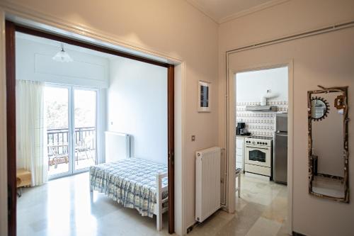 een slaapkamer met een deur naar een keuken bij Ragia beach apartment in Póros