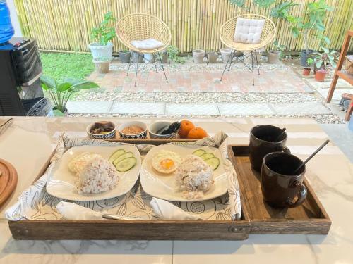 um tabuleiro com dois pratos de comida numa mesa em Balai Lawaan Cozy Homestay em Iloilo