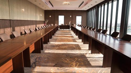 una gran sala de conferencias con una mesa larga y sillas en فندق سنبات بلاتينيوم, en Jazan