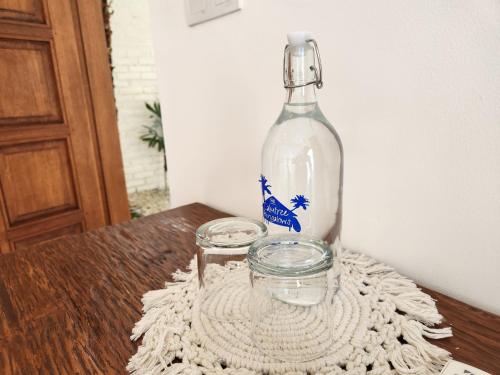 a bottle sitting on a table with two glass jars at The Calmtree Bungalows in Canggu