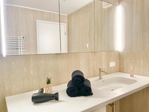 a bathroom with a sink and a black towel at Riverfront Apartment with Balcony and AC in Vienna