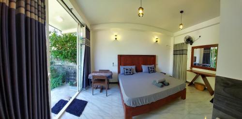 a bedroom with a bed and a table and a window at CHEN VILLA - Near Airport in Negombo