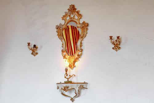 a gold mirror hanging on a white wall at Nordpalais vor Sylt in Emmelsbüll-Horsbüll